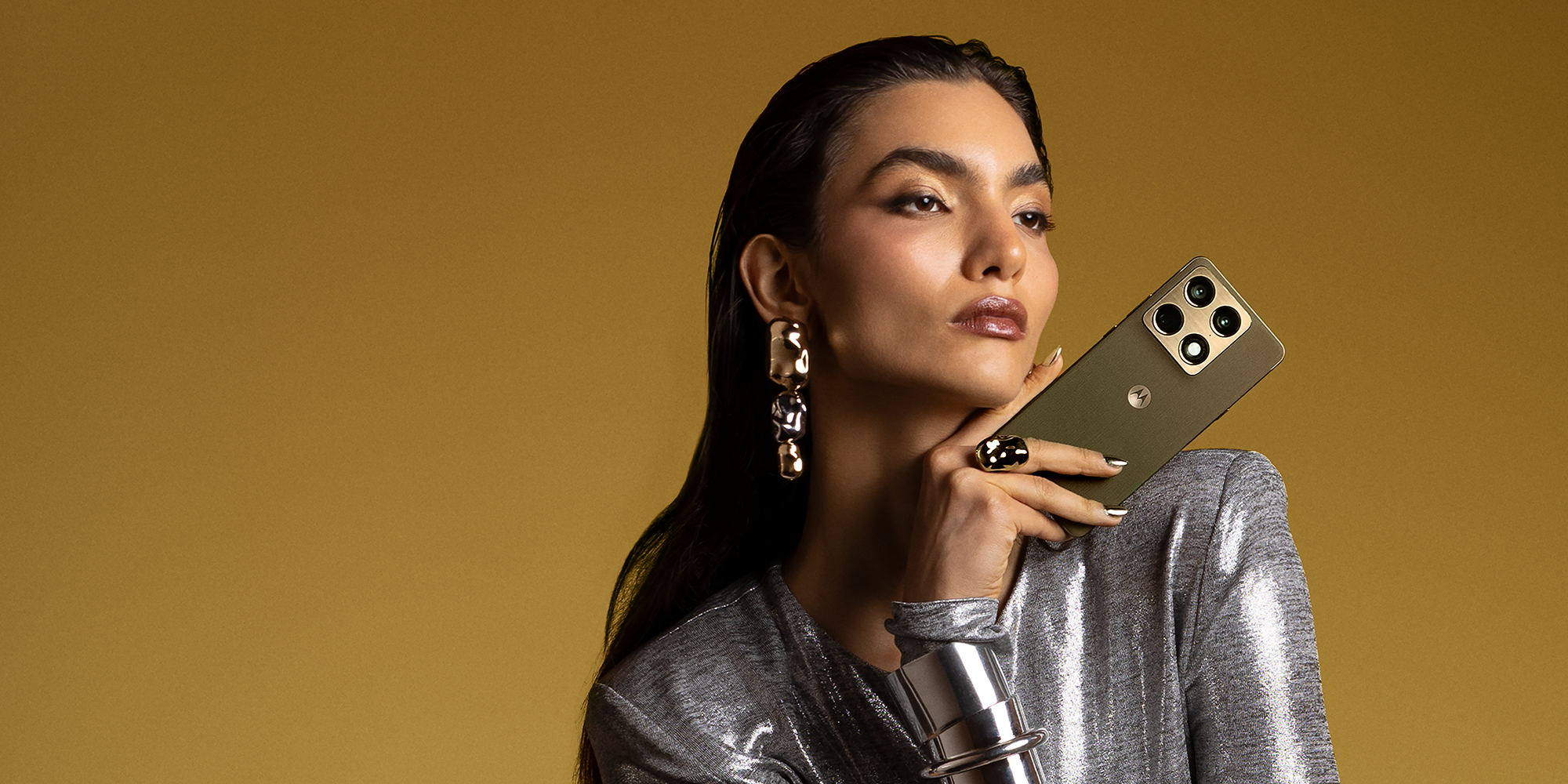 en dame som holder motorola signature i fargen pantone martini olive i hånden