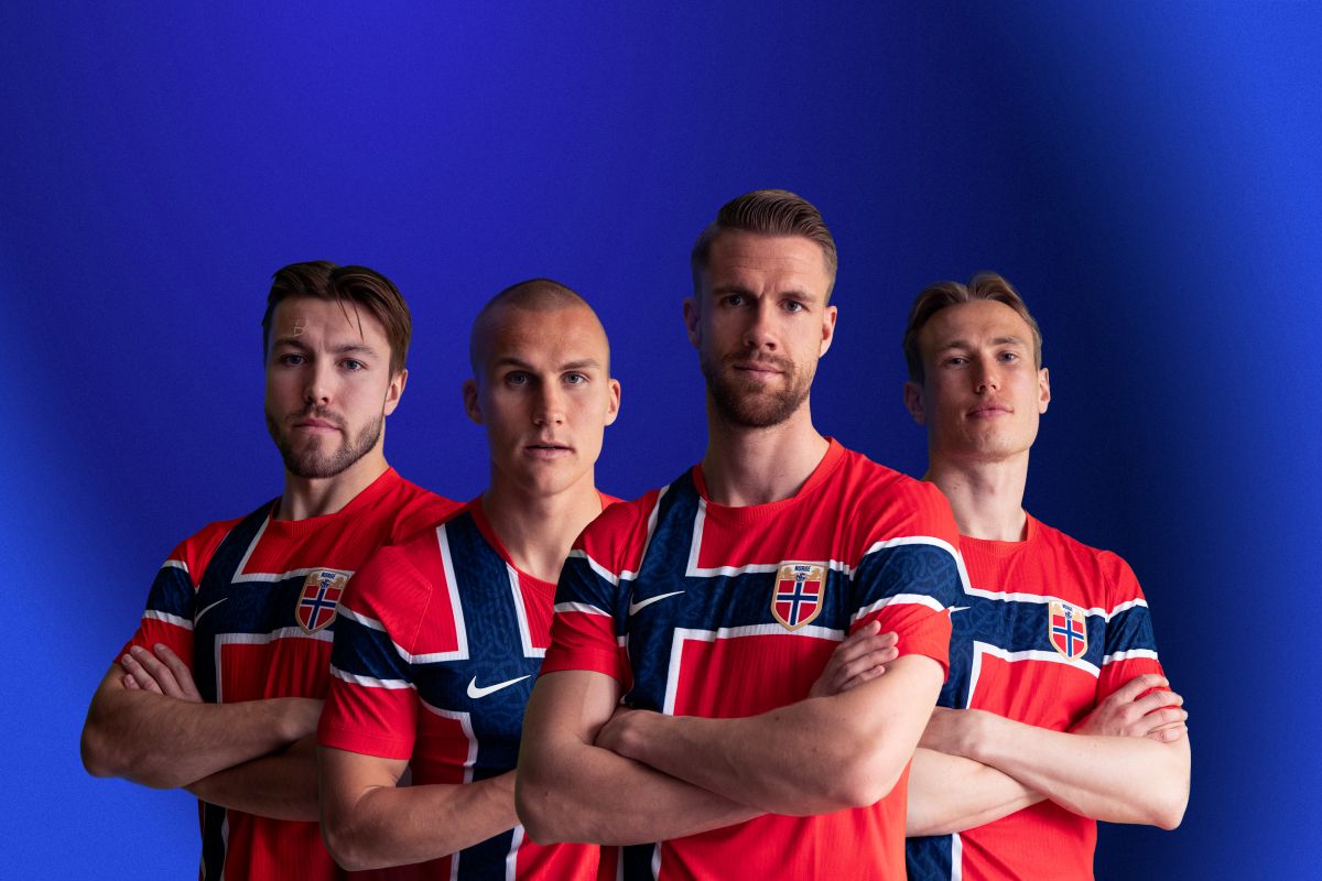 Fire menn i fotballdrakt med det norske flagget
