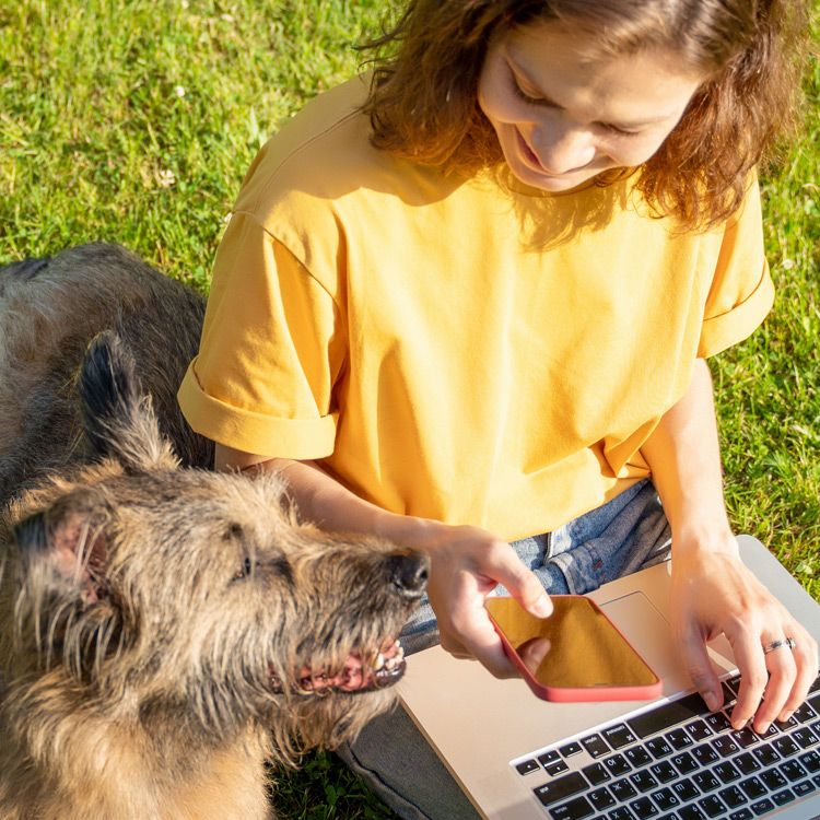 jente sitter med mobil og pc på hytta