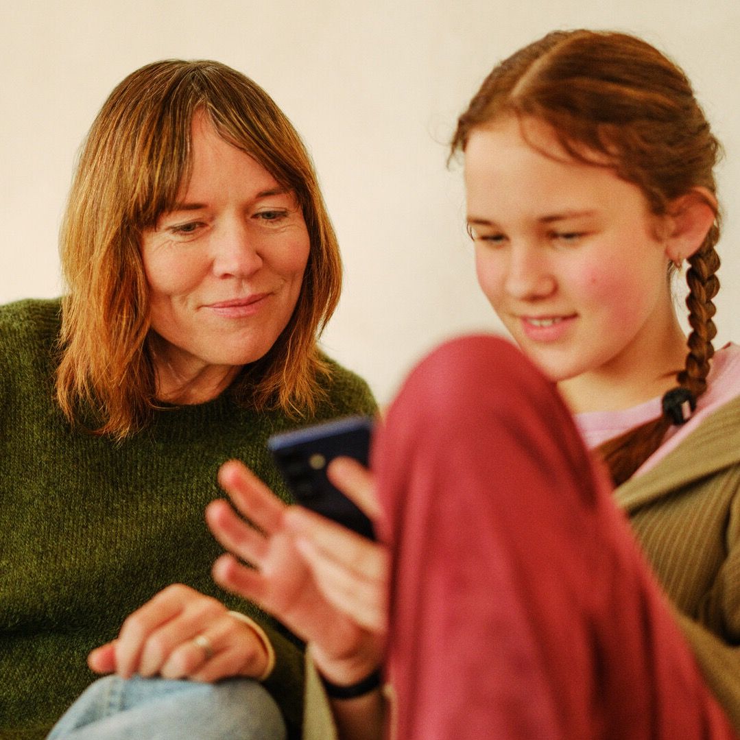 Mor og datter med mobil i sofaen