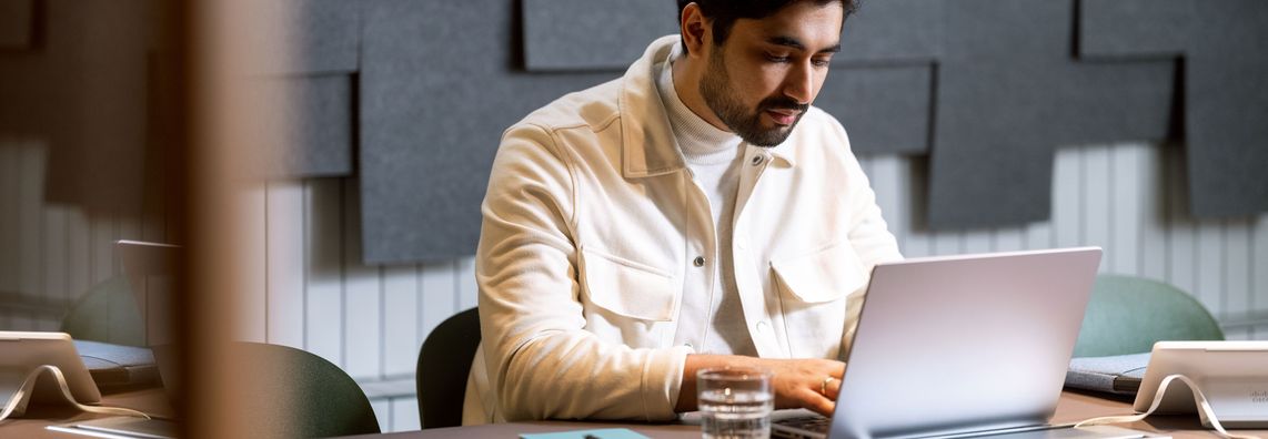 Mann sitter på laptop koblet til internett via bredbånd