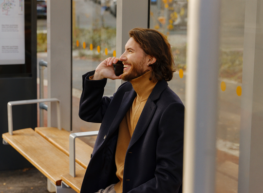 kontakt kundeservice - mann i busslomme med mobiltelefon inntil øret