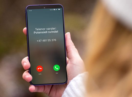 Mobil som viser svindelvarsel i Se Hvem