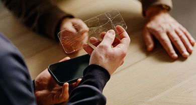 en mann i telenorbutikken fjerner en knust skjermbeskytter