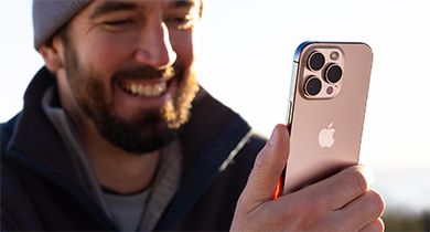 Mann som ser på noe morsomt på iPhone 16 Pro Max