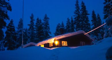Jenter som sitter foran en hytte på fjellet