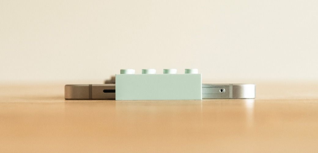 Lysblå LEGO-kloss liggende foran en Samsung Galaxy S25 Edge