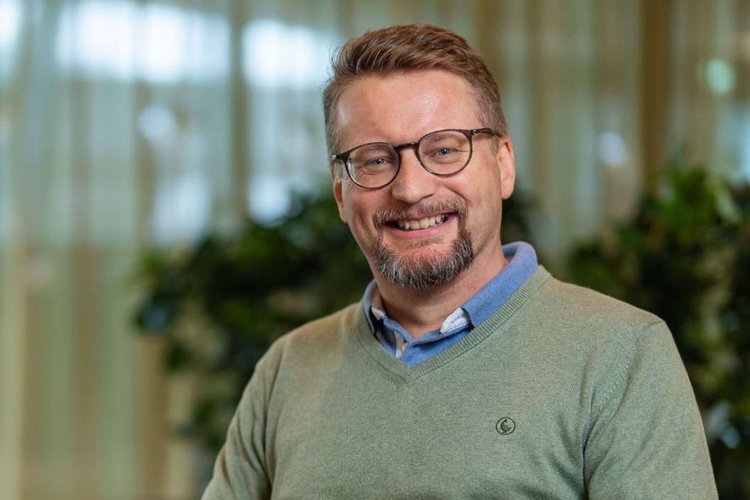 Mann sitter i grønn genser