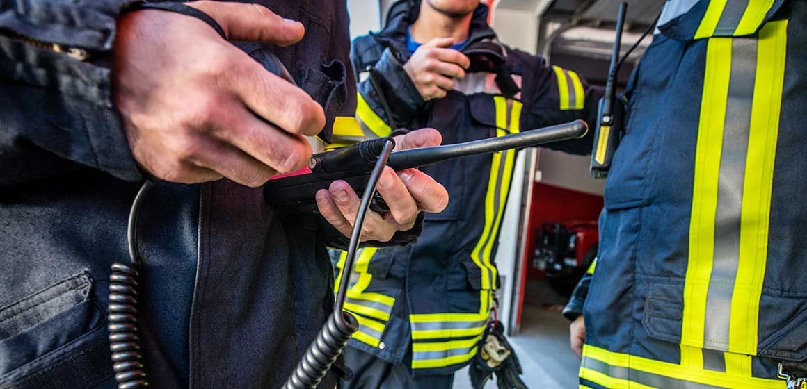 Brannmenn i uniform med radioutstyr i beredskap