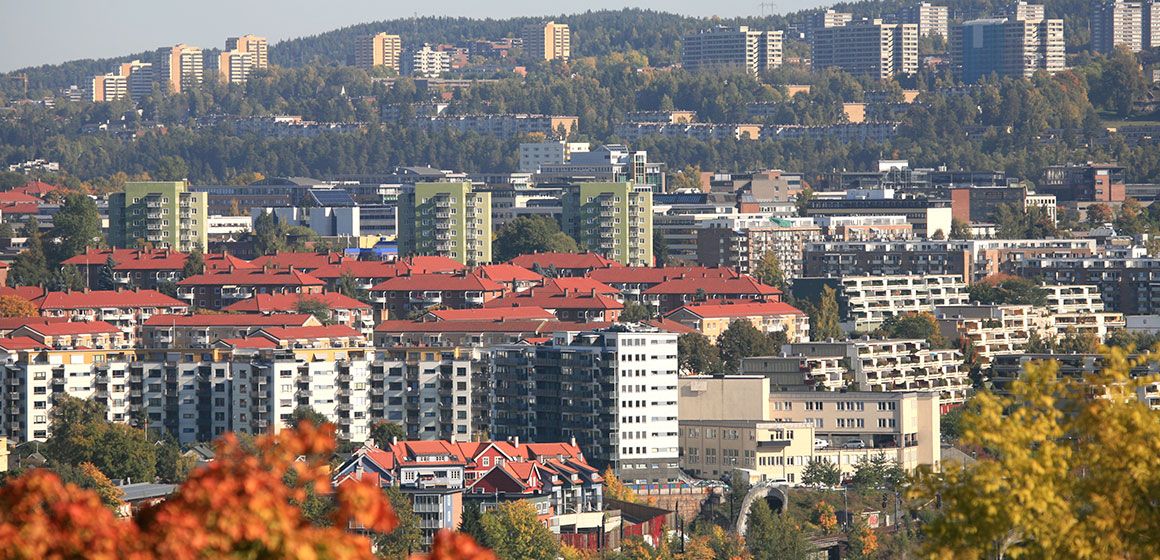 Utsikt over Oslo med boligblokker, røde tak og grønne omgivelser - fremtidsrettet borettslag