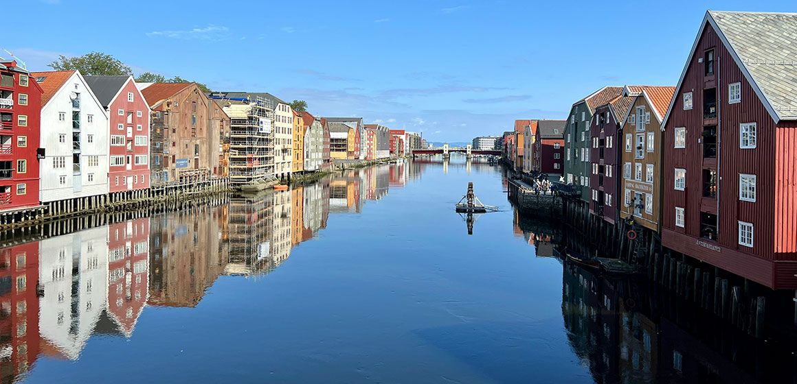 Fargerike trebygninger ved elvebredden i Trondheim 