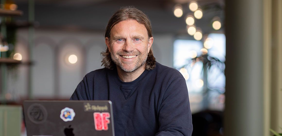 Person sitter ved en bærbar PC i et moderne arbeidsmiljø