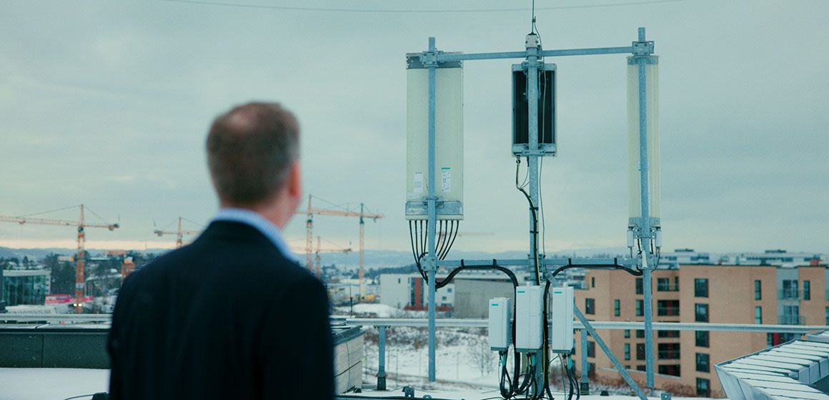 Person ser på mobilmast på tak med fokus på robusthet i mobilnettet