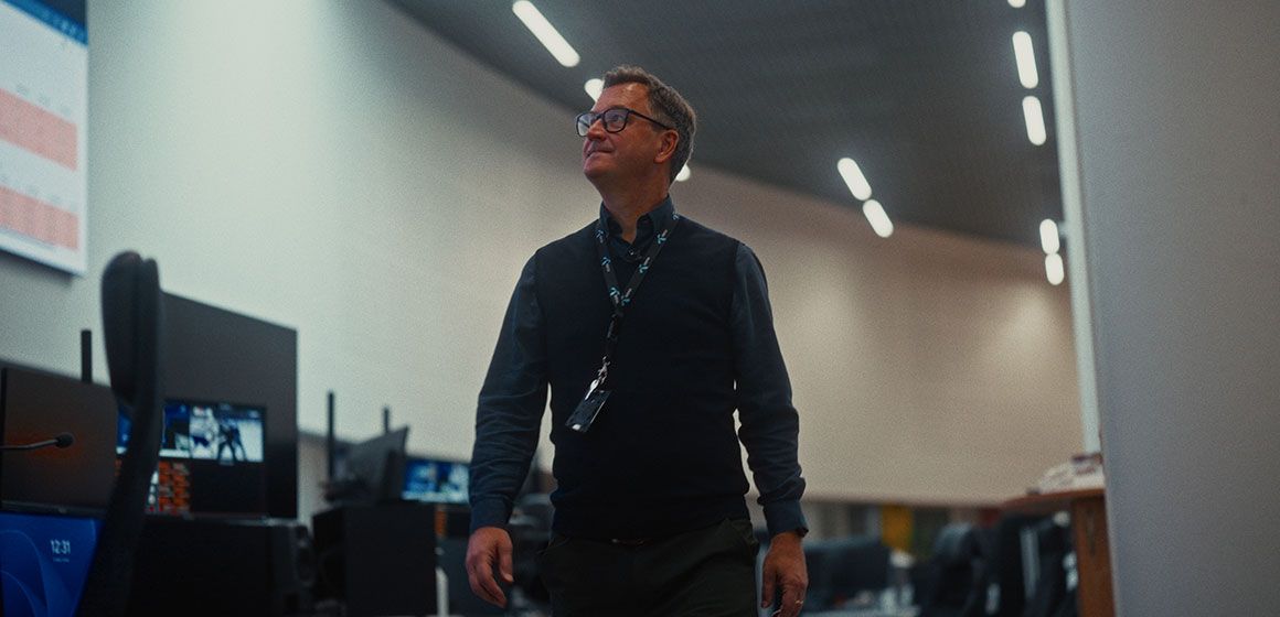 Person i kontormiljø med skjermer og moderne belysning