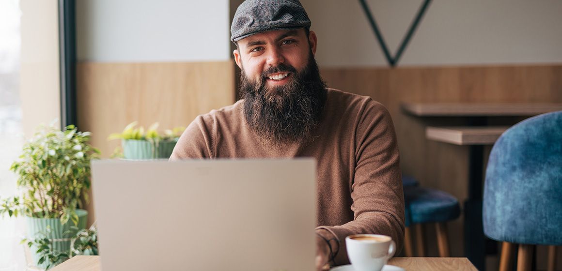 Person jobber på laptop for å velge bredbåndsløsning til bedriften