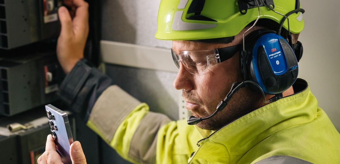 Industriarbeider med gul hjelm bruker avansert 5G til å jobbe sikkert og effektivt