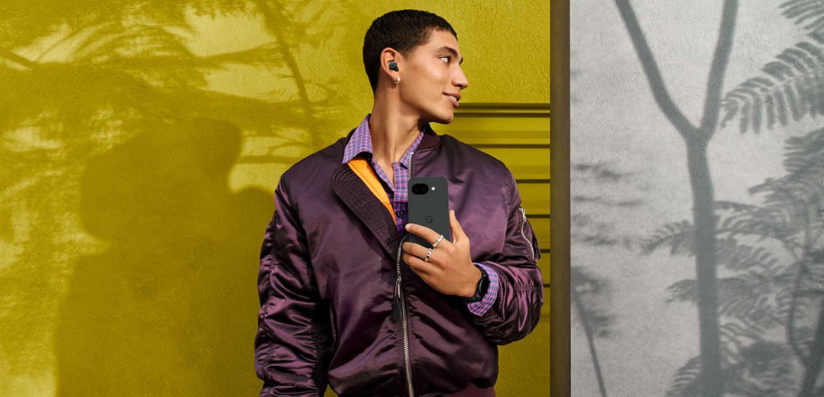 en mann holder en google pixel 10a i fargen obsidian foran seg