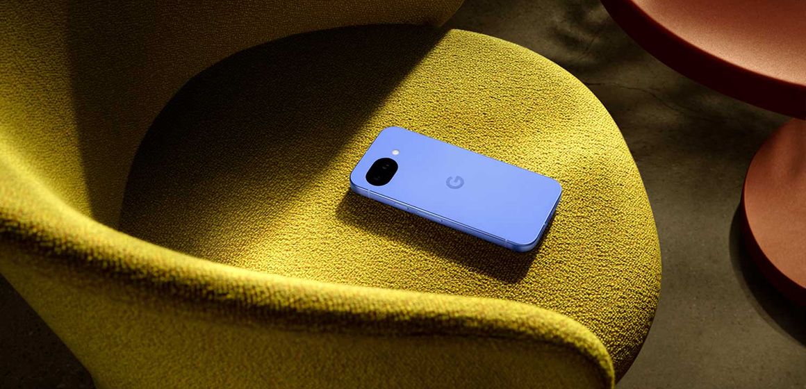 en google pixel 10a i fargen lavender ligger på en sennepsgul stol