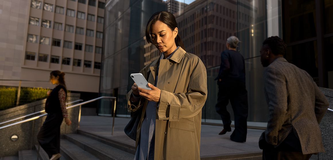 en dame som sjekker sin nye iphone 17e på gaten