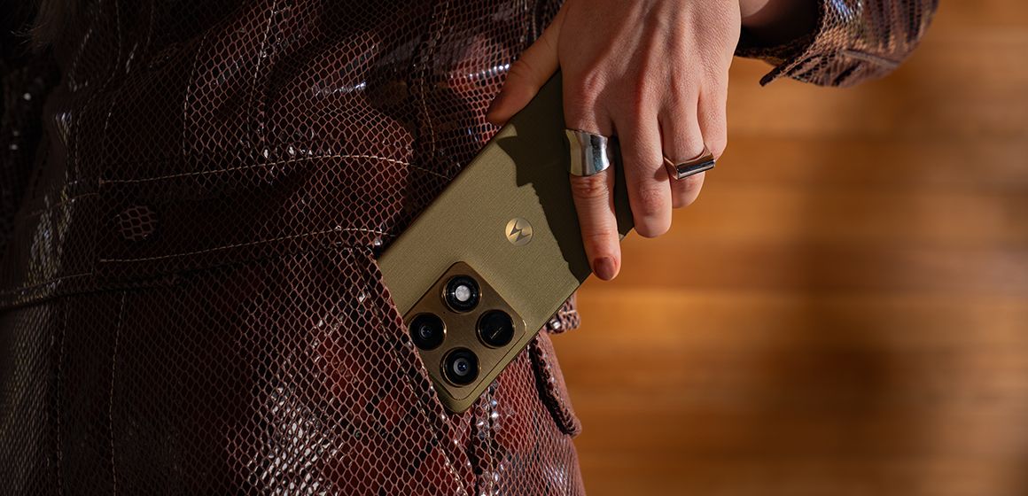 en dame legger sin motorola signature i fargen pantone martini olive i lommen