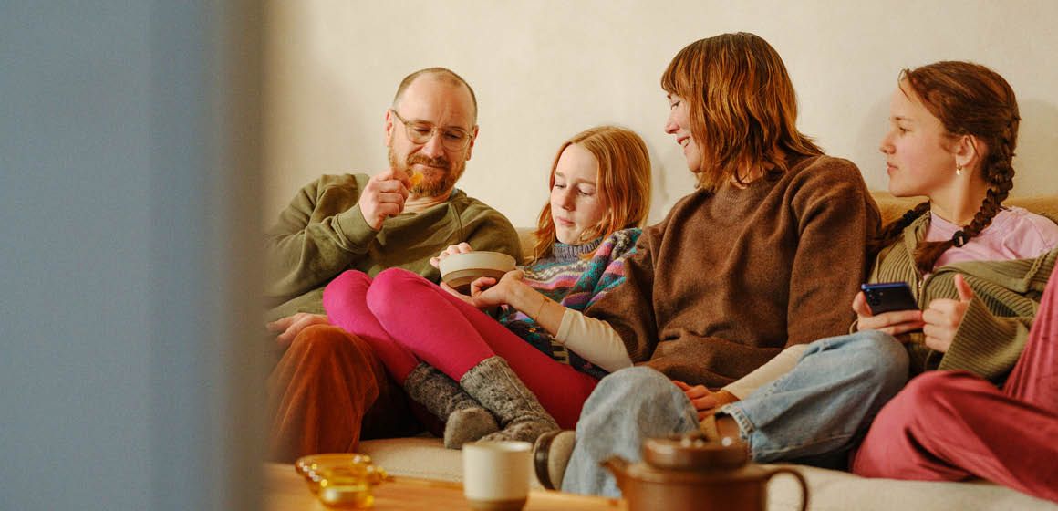En familie som sitter i sofaen