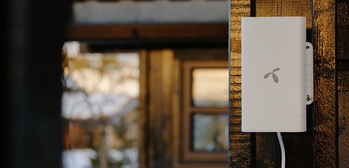 Telenor ruter montert på hyttevegg med vindu i bakgrunnen