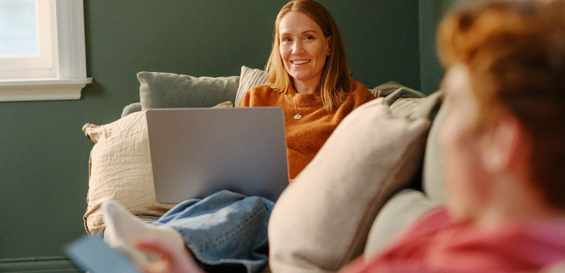 Kvinne i sofa med laptop