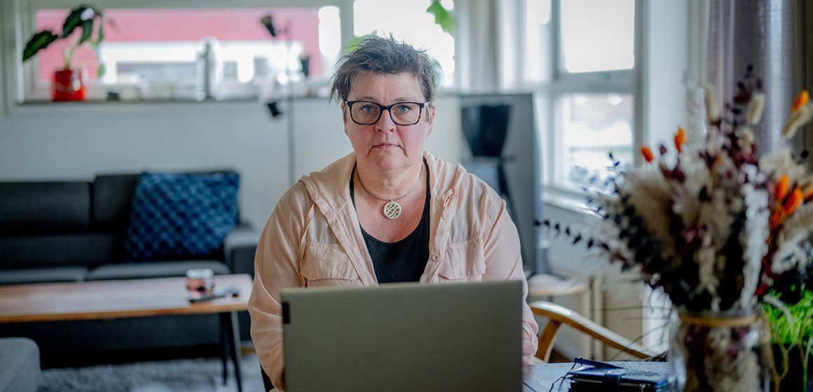 Ann-Kristin arbeider på bærbar PC i et lyst stueinteriør