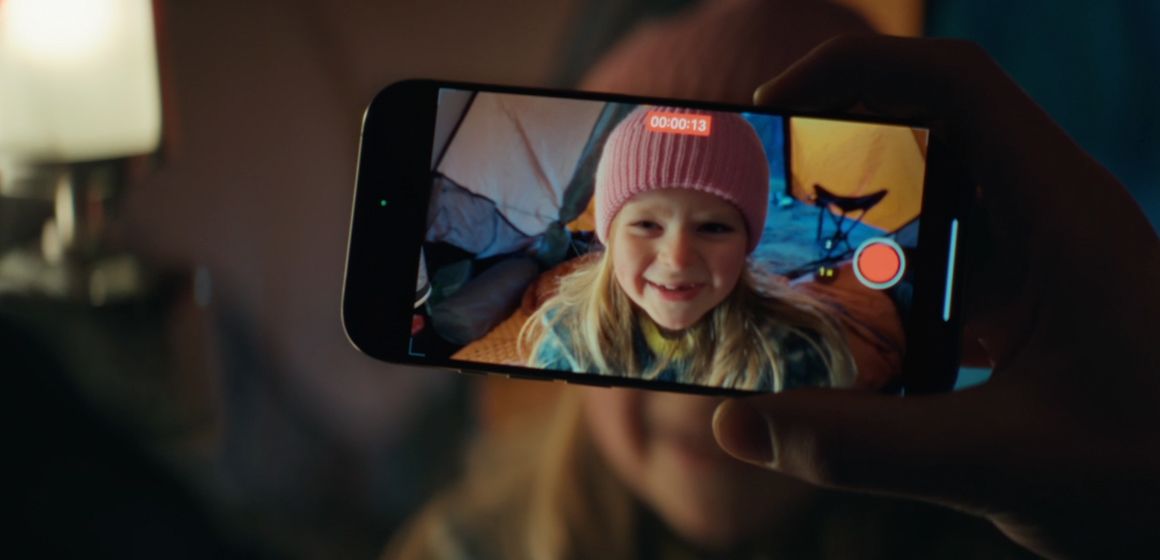 En hånd holder en mobil med videoopptak innendørs i teltmiljø