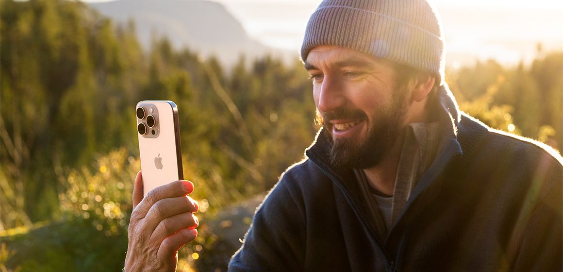 bilde av en mann som ser på sin iphone 16 pro max