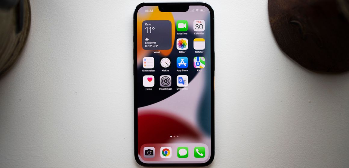 hjemskjermen på iPhone 13 som viser apper og været