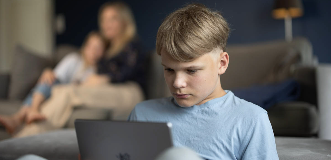 Barn foran laptop i stuen på hytta