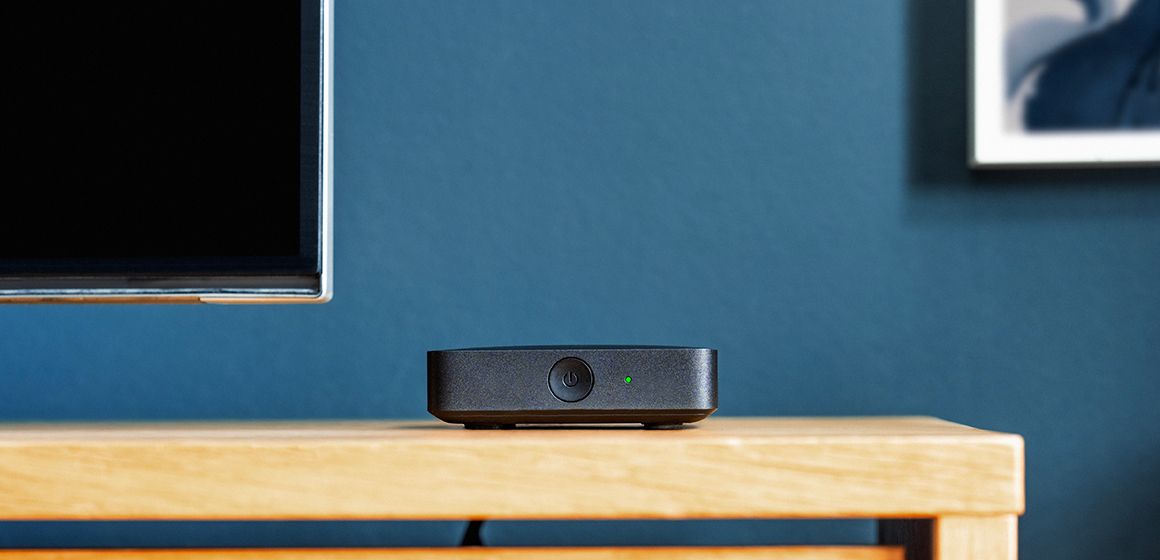 Svart t-we boks III på trebord foran en blå vegg