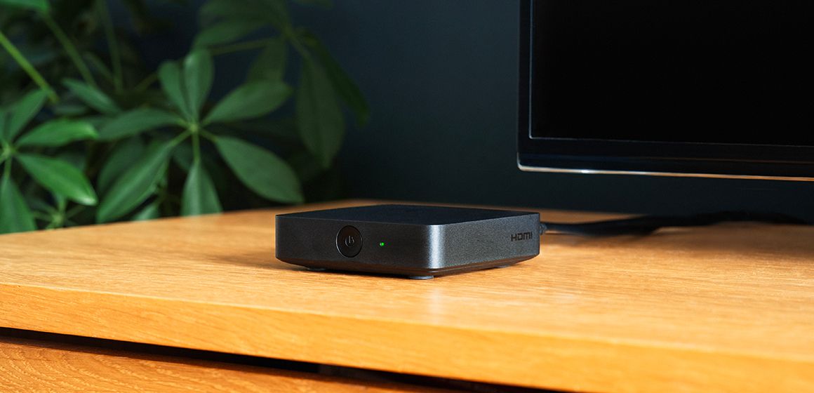 Sort t-we boks III på et bord ved siden av en TV