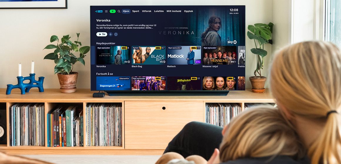 Bilde av mor og sønn som ser på TV fordi de vet hvordan aktivere strømmetjenester. 