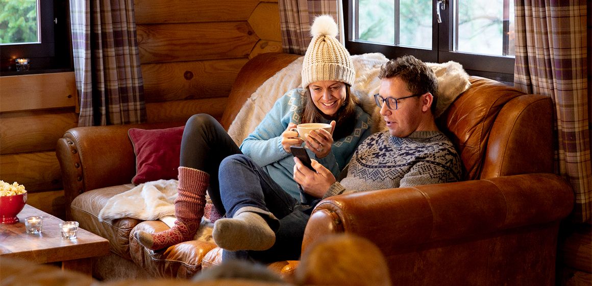 Bilde av et par som bruker telefonen sin med T-We på hytta. 