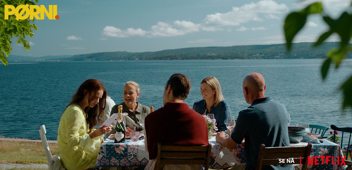 Familie rundt et bord ved en innsjø, relatert til serien Pørni