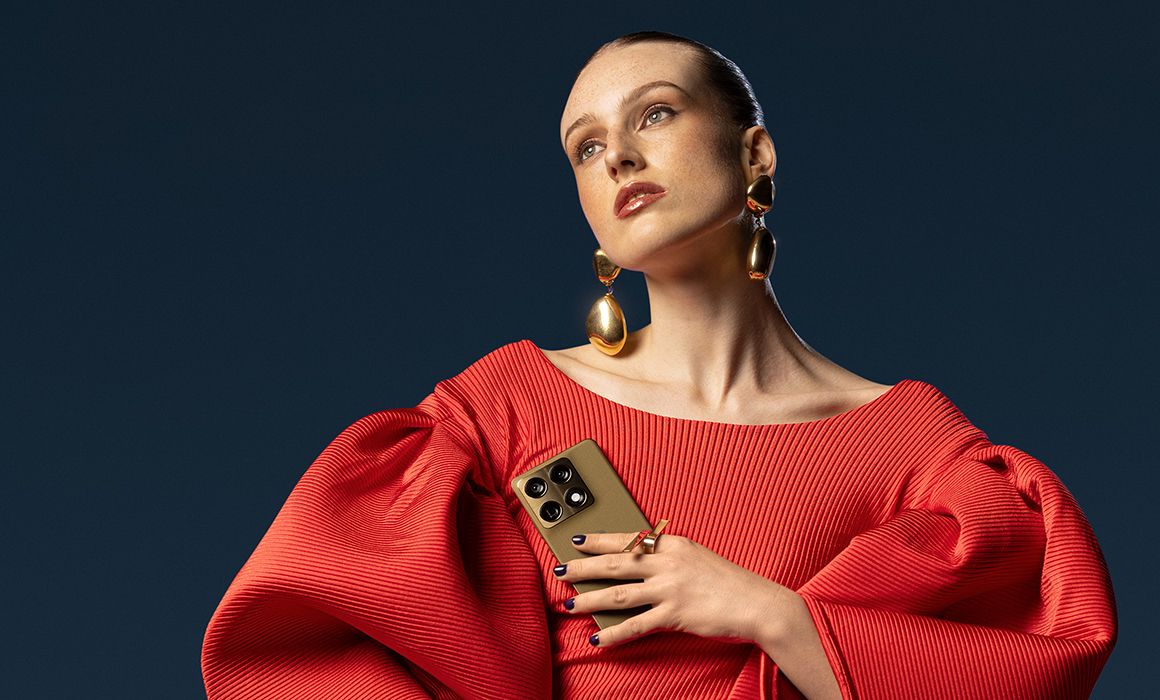 en dame med rød kjole holder motorola signature i fargen martini olive