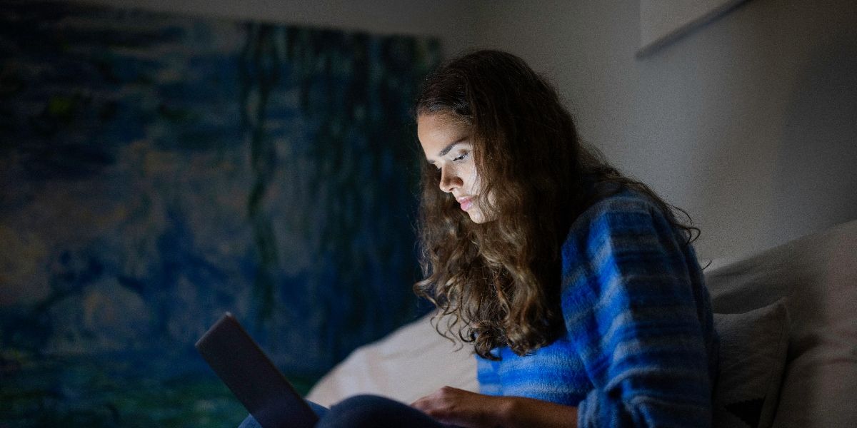 Ung kvinne som rydder i innboksen på laptop