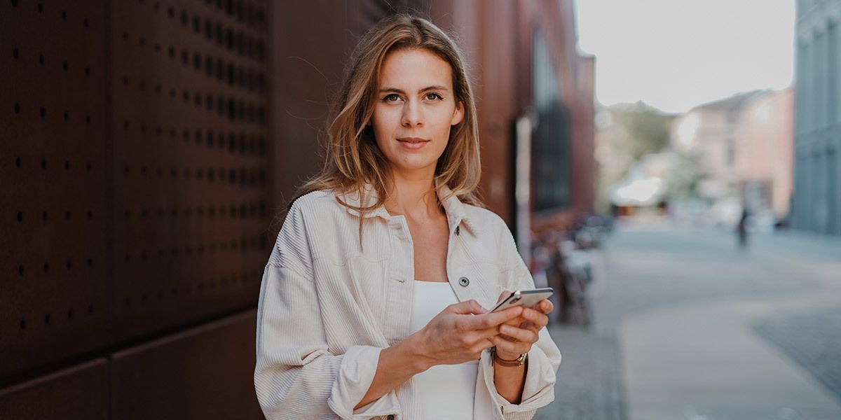 Kvinne som bruker Nettvern+ på mobilen og unngår å bli svindlet