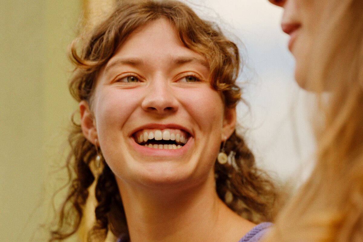 Person med svart frakk og lyseblått skjerf holder en mobiltelefon