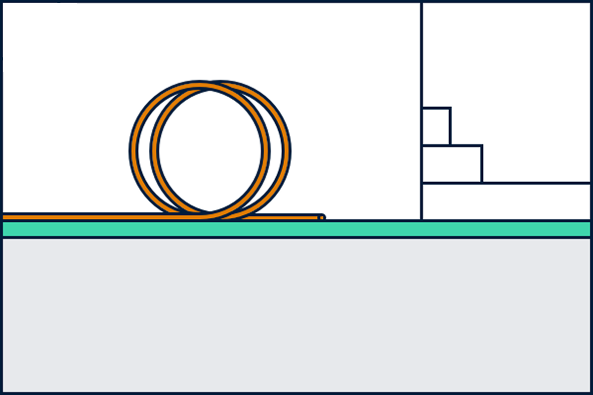 En oransje fiberkabel ligger i en kveil på bakken utenfor et hus.