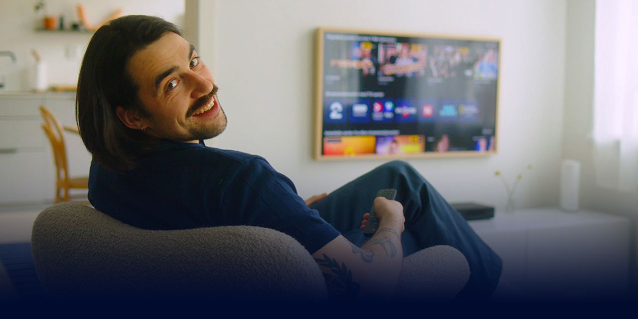 Person ser på en TV-skjerm med ulike strømmetjenester