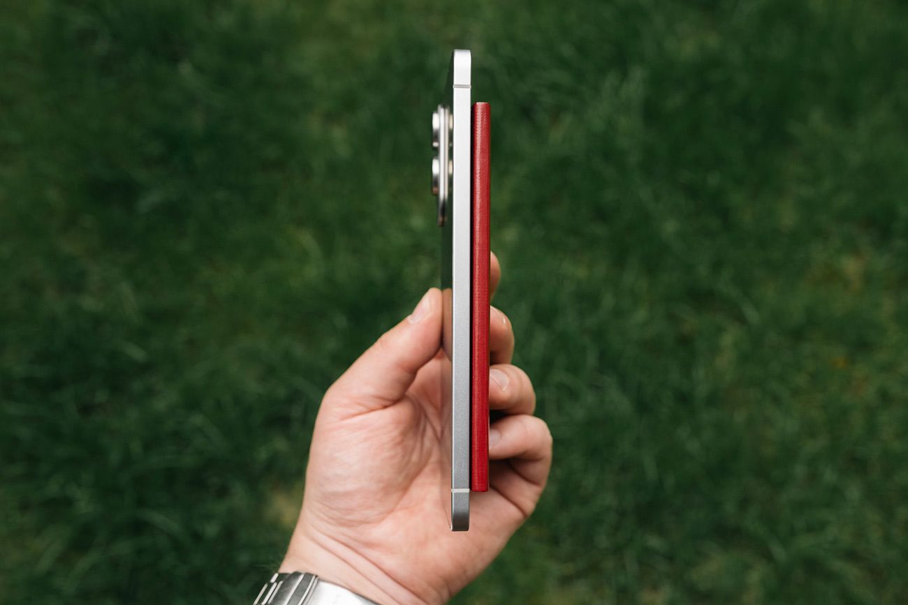 Hånd holder en Samsung Galaxy S25 Edge og et norsk pass
