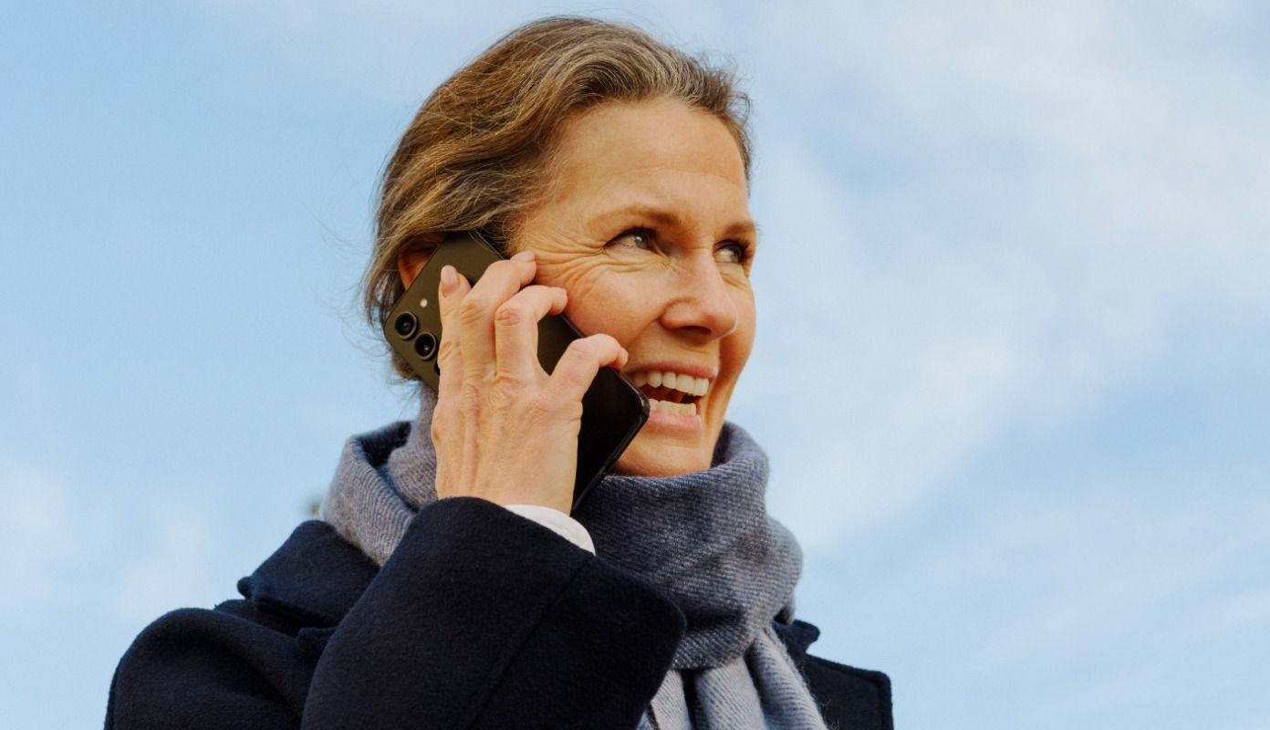 Person snakker i telefon, "Nyhets" annonse for trygg telefonsamtale