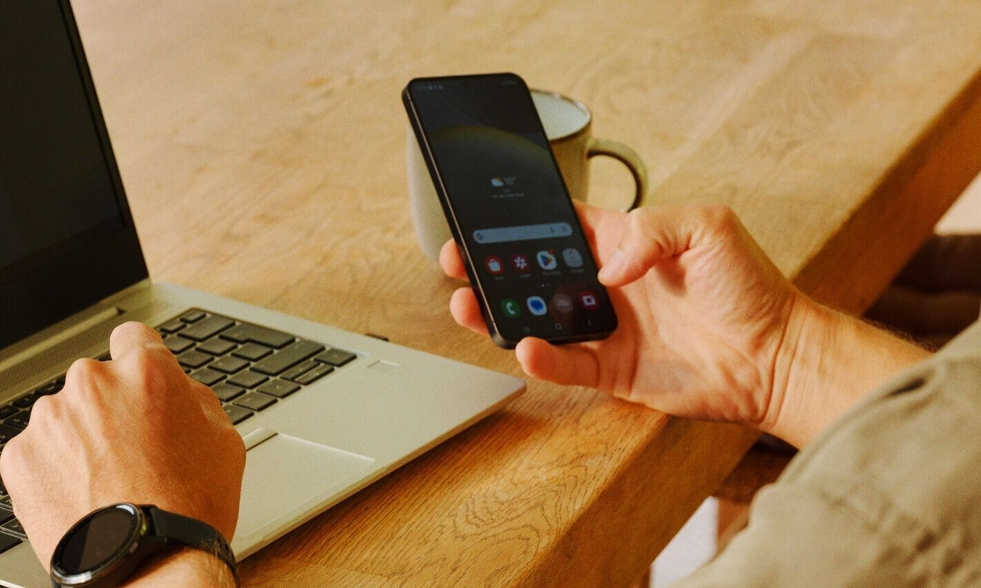 Mann med mobil og PC