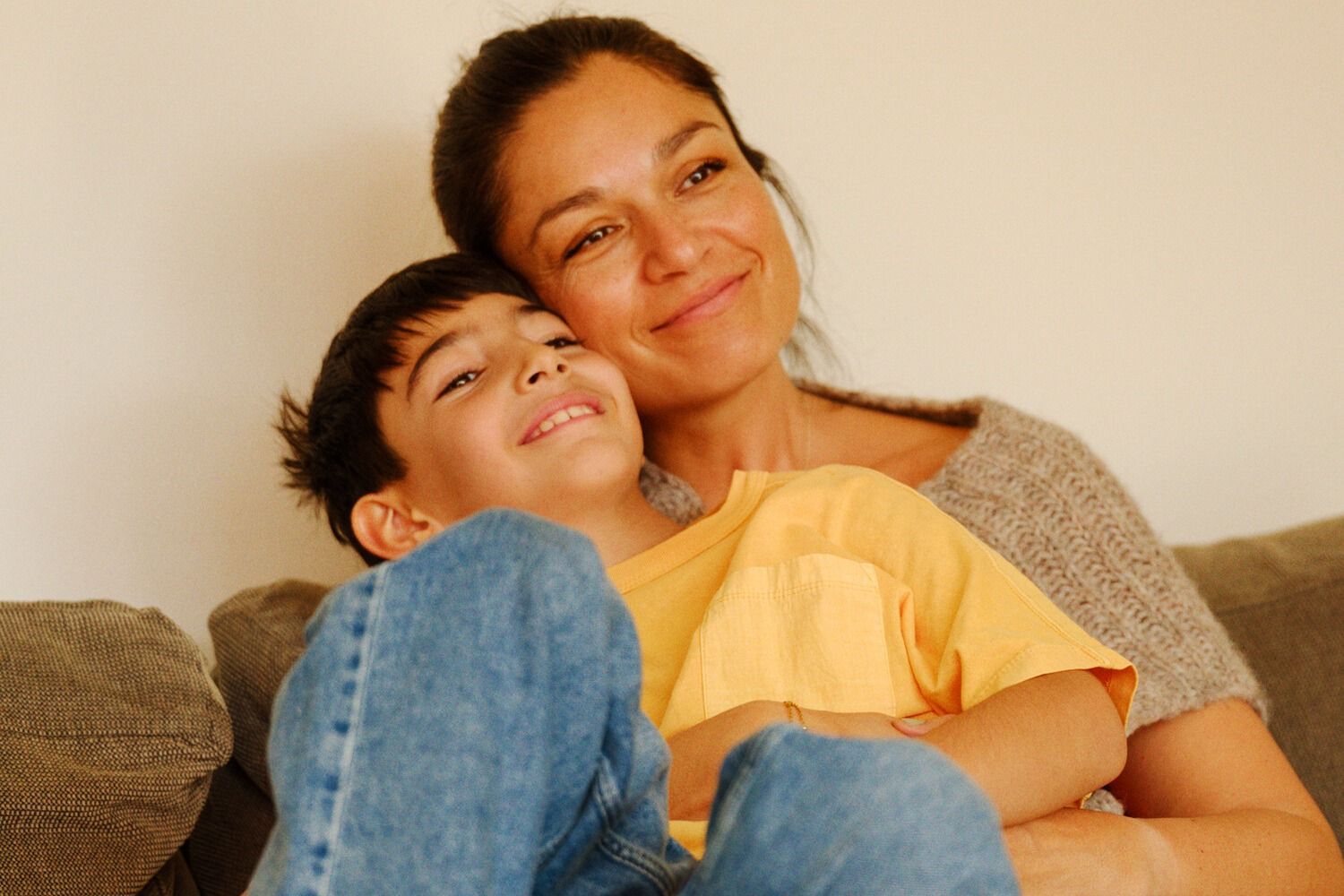 Person med svart frakk og lyseblått skjerf holder en mobiltelefon