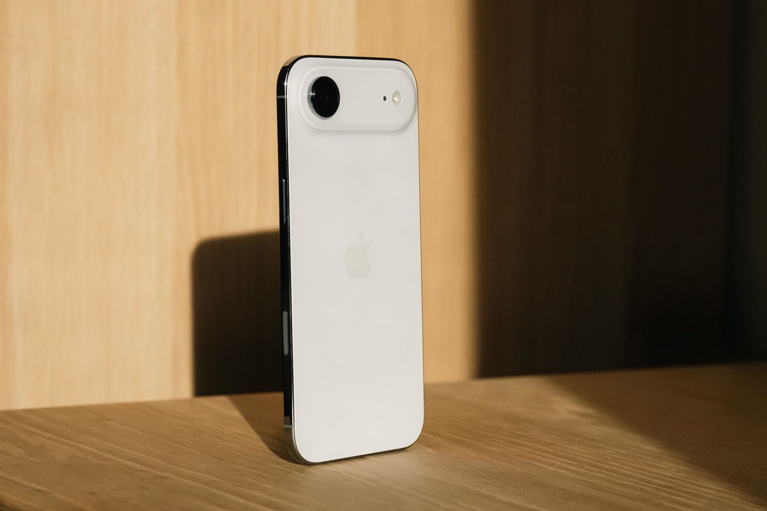 iPhone Air står oppreist på et bord i sollys