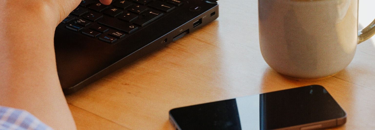 Kvinne på kontor med mobil og pc
