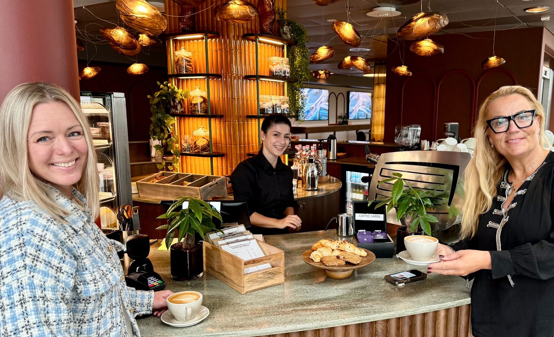 Moderne kafé med kaffedrikker, bakverk og dekorative lamper